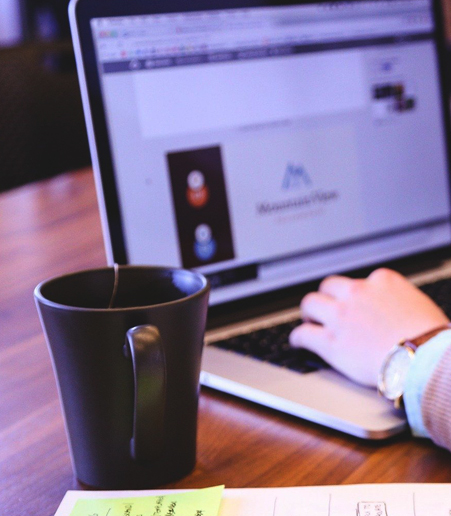 Taza de café a un lado de computadora